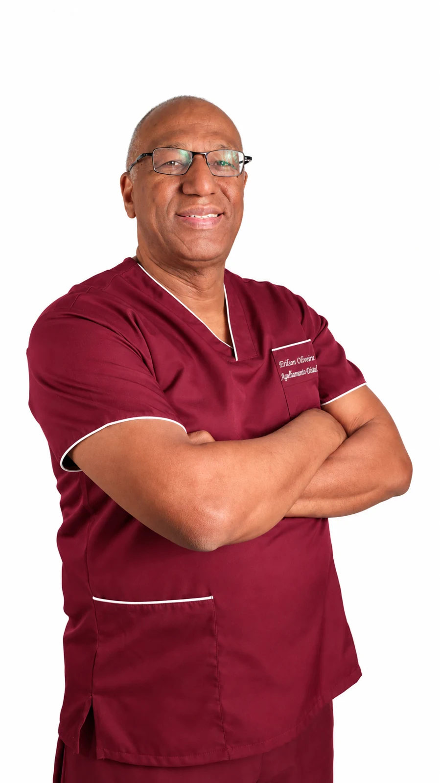 Erilson de Oliveira em pé, com os braços cruzados e uniforme vinho